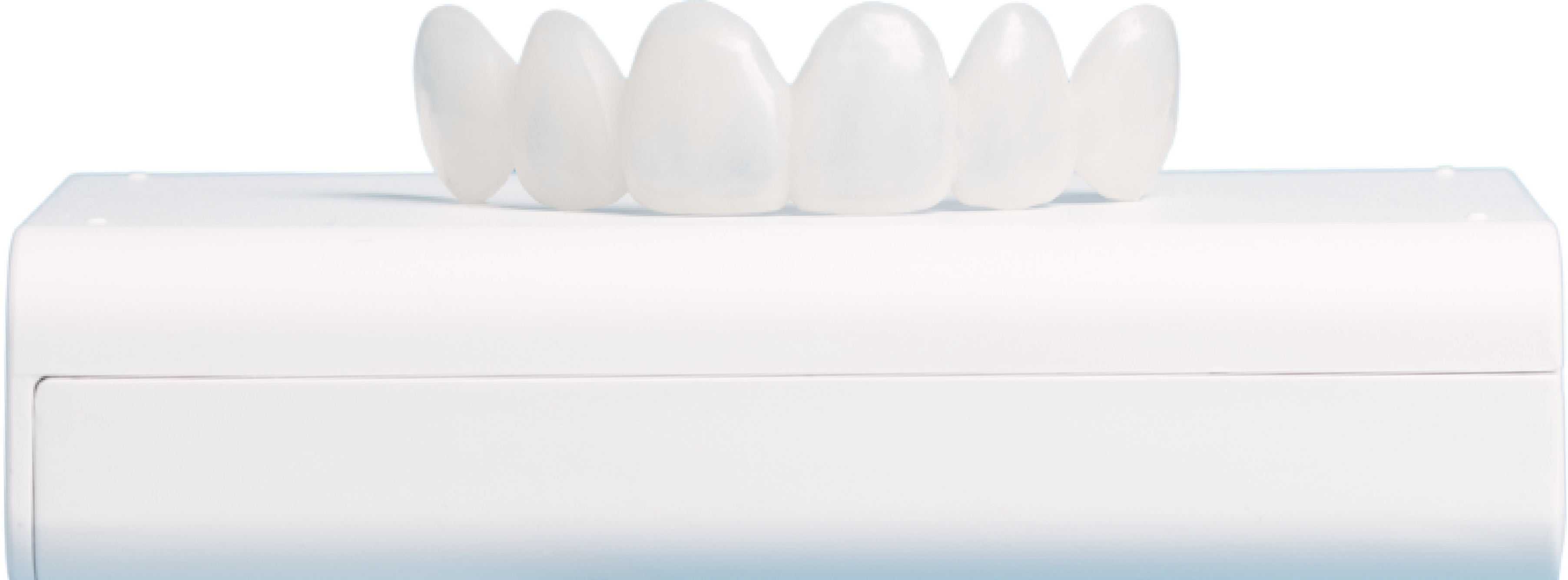 A set of dental veneers displayed on a white surface